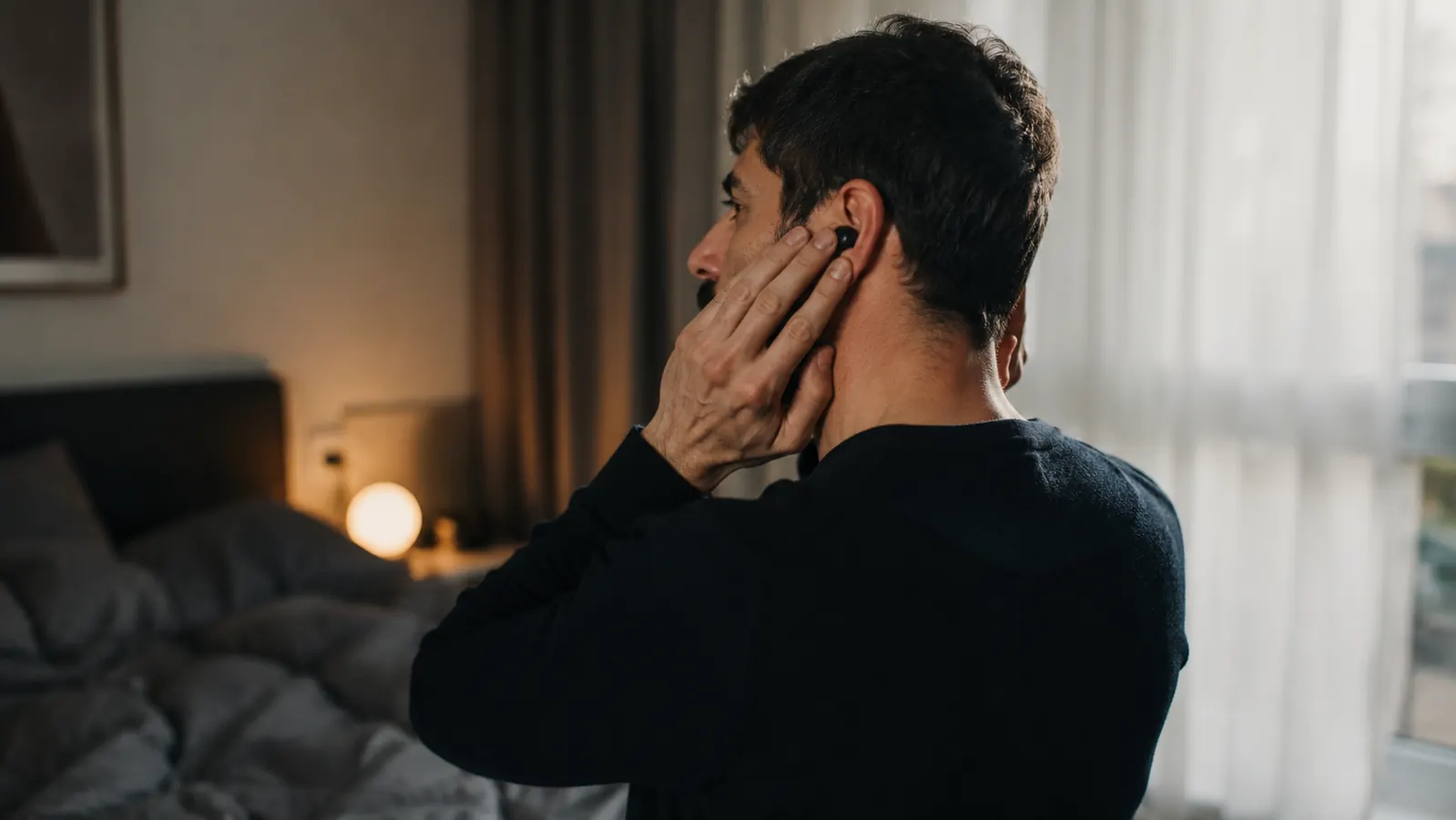 A person cupping both hands over their ears to test how much quieter the room sounds with foam plugs already in